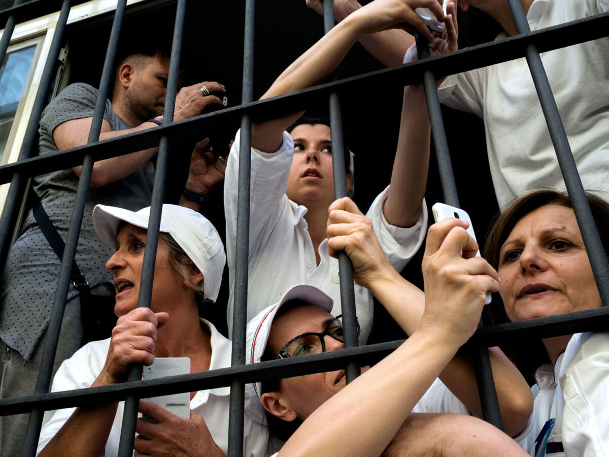 People waiting for Pope behind the fence