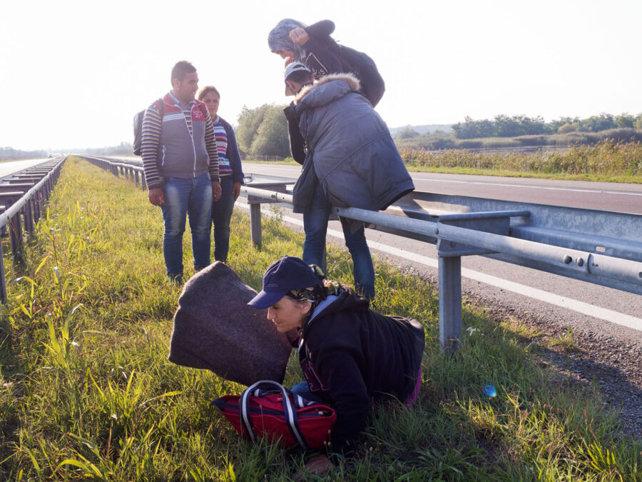 People cross a big road with helping each other